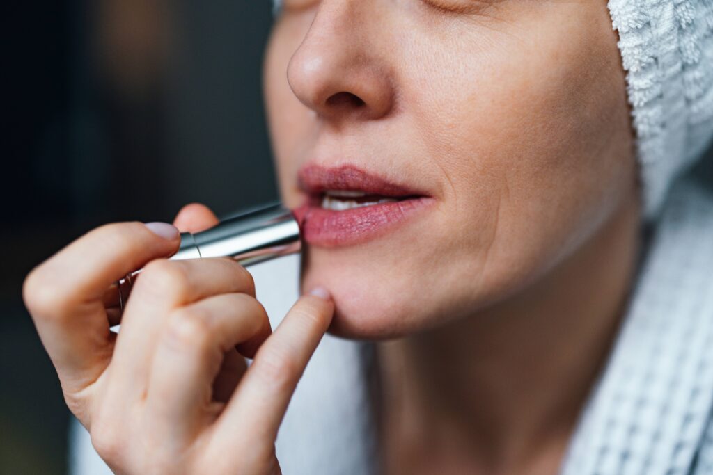 close up of woman applying lipstick.