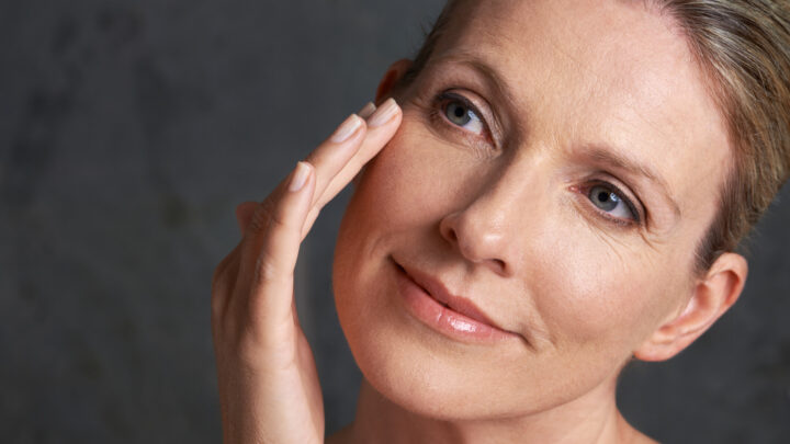 mature woman applying a retinol serum to her face