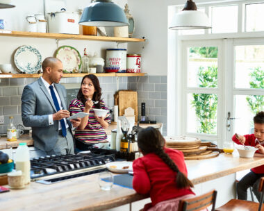 Family of four in kitchen discussing budgeting
