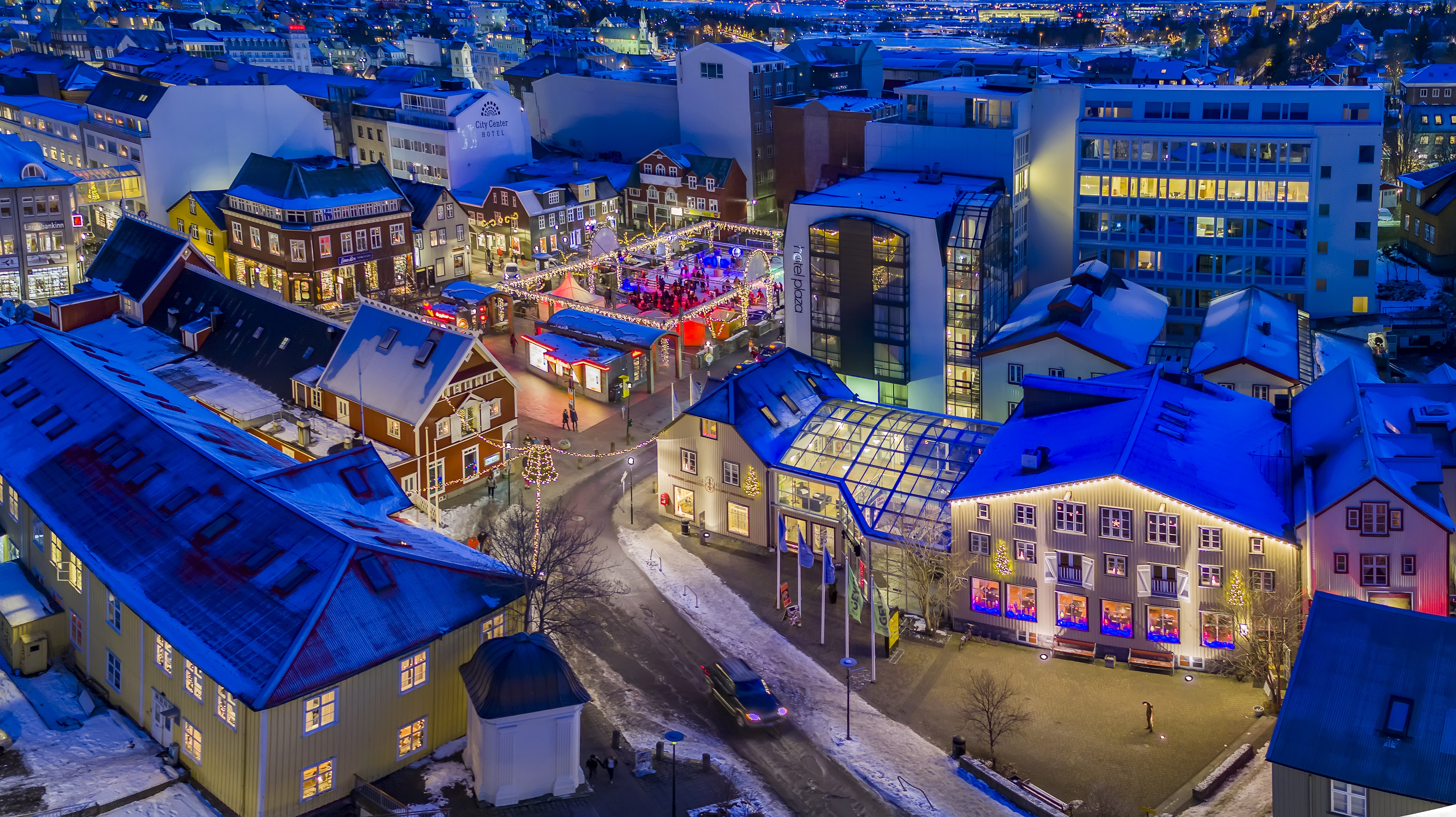 white christmas destinations - Aerial view of downtown Reykjavik during Christmas, including a small outdoor skating rink.