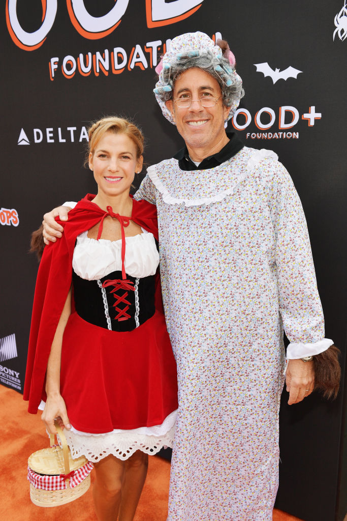 Two people in Halloween costumes, one as Little Red Riding Hood, the other as the wolf in granny's nightdress.