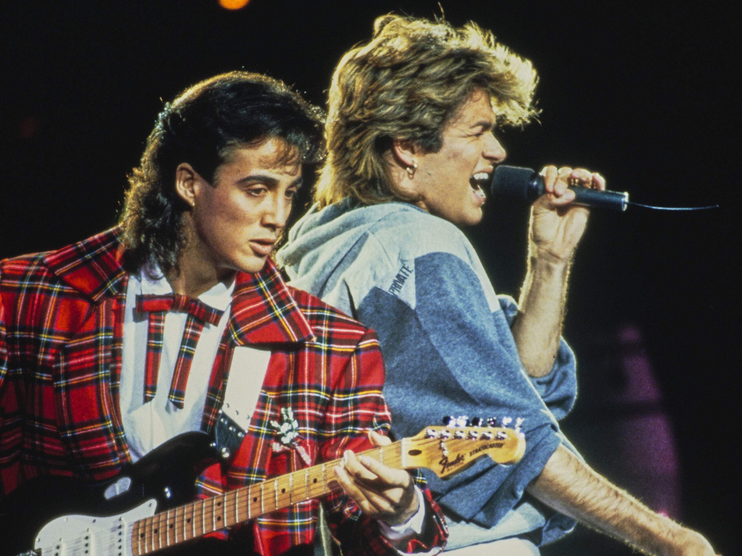 George Michael (1963-2016) and Andrew Ridgeley (on left) of Wham! performing together live on stage during the pop duo's 1985 world tour, January 1985. 'The Big Tour' took in the UK, Japan, Australia, China and the US. (Photo by Michael Putland/Getty Images)