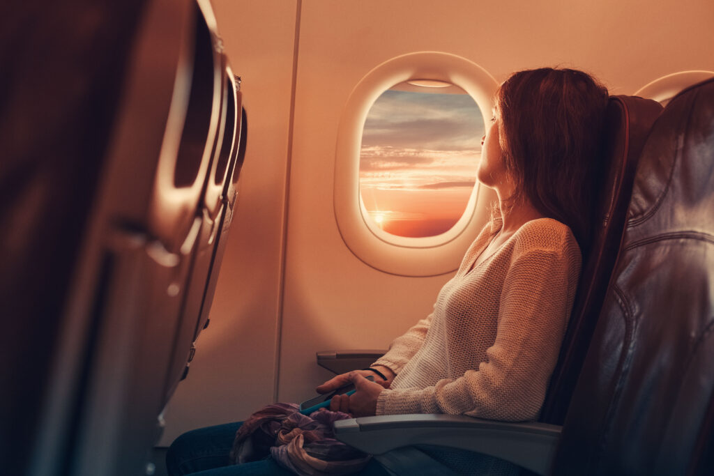woman on plane looking out window - black friday flight sales