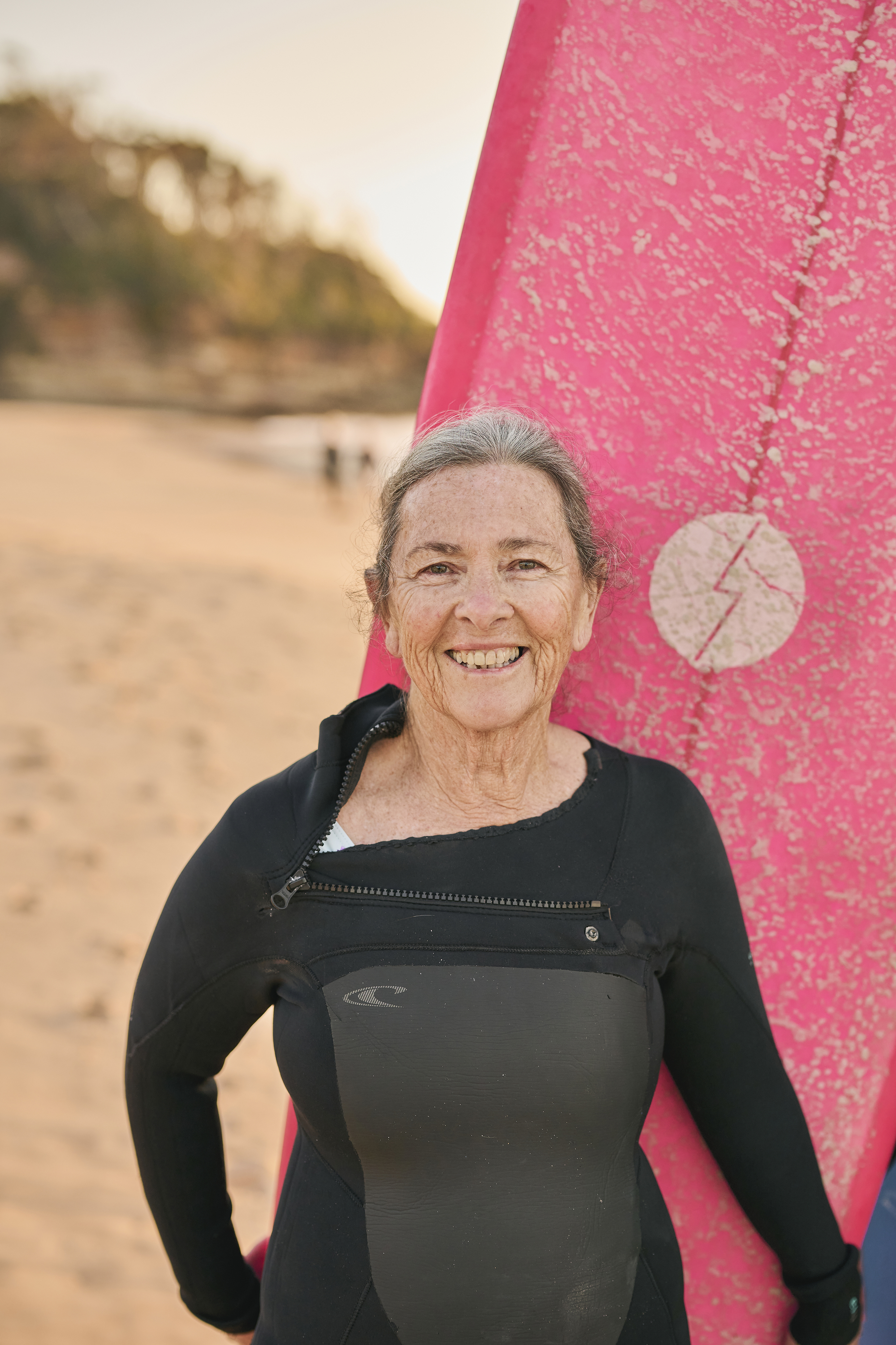 Australian female surfer Donna Miles in her wetsuit with her surfboard. 