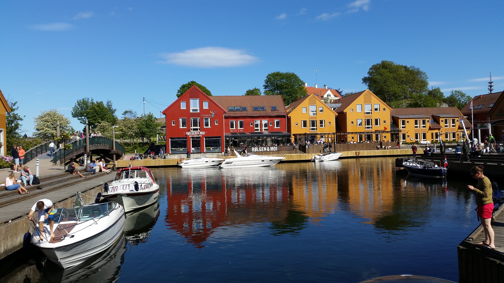 Kristiansand in Norway. Colourful buildings in front of a marina with small boats docked.