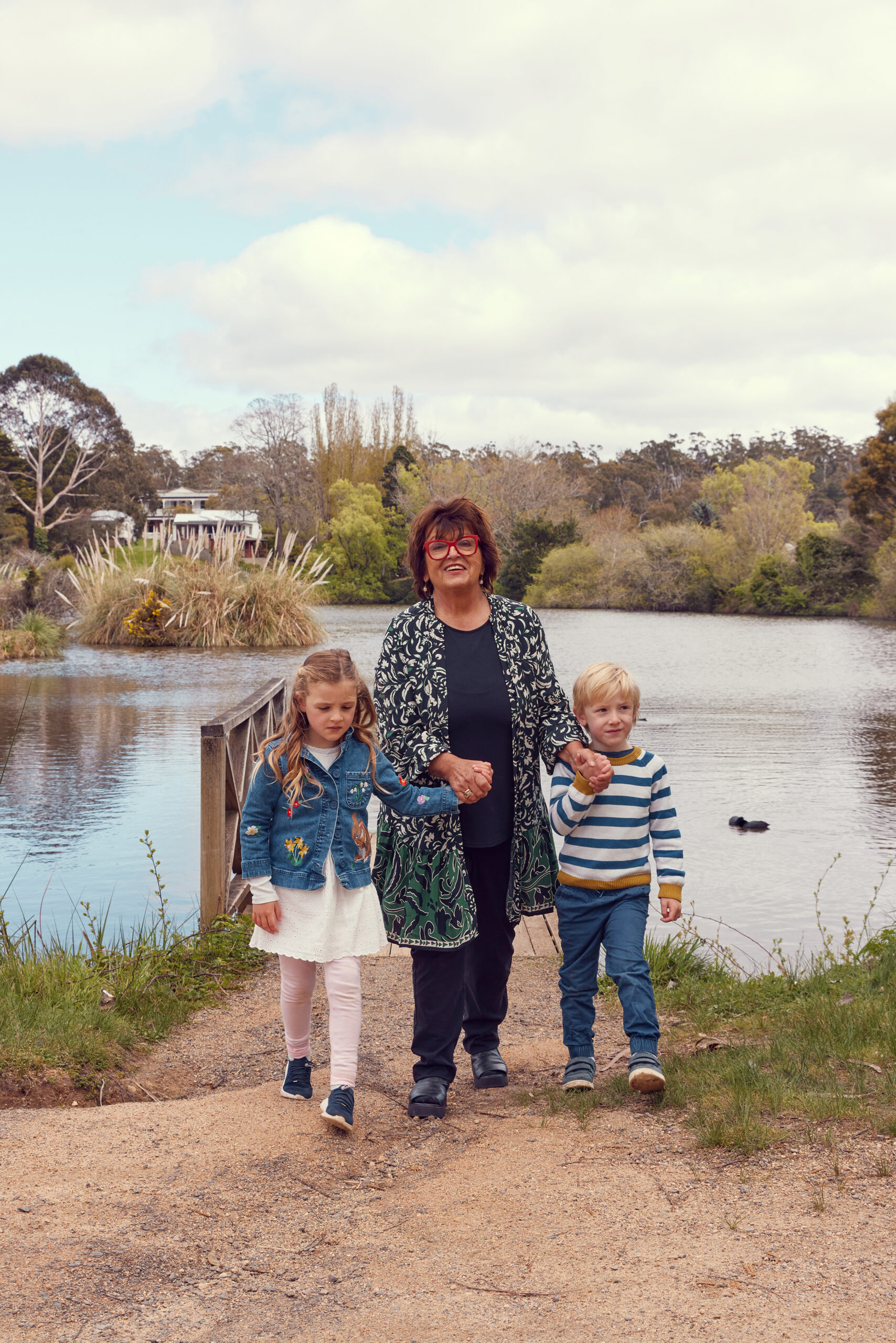Alla Wolf-Tasker walks back from the lake with her grandchildren, Maya and Alexei, holding each of her hands.