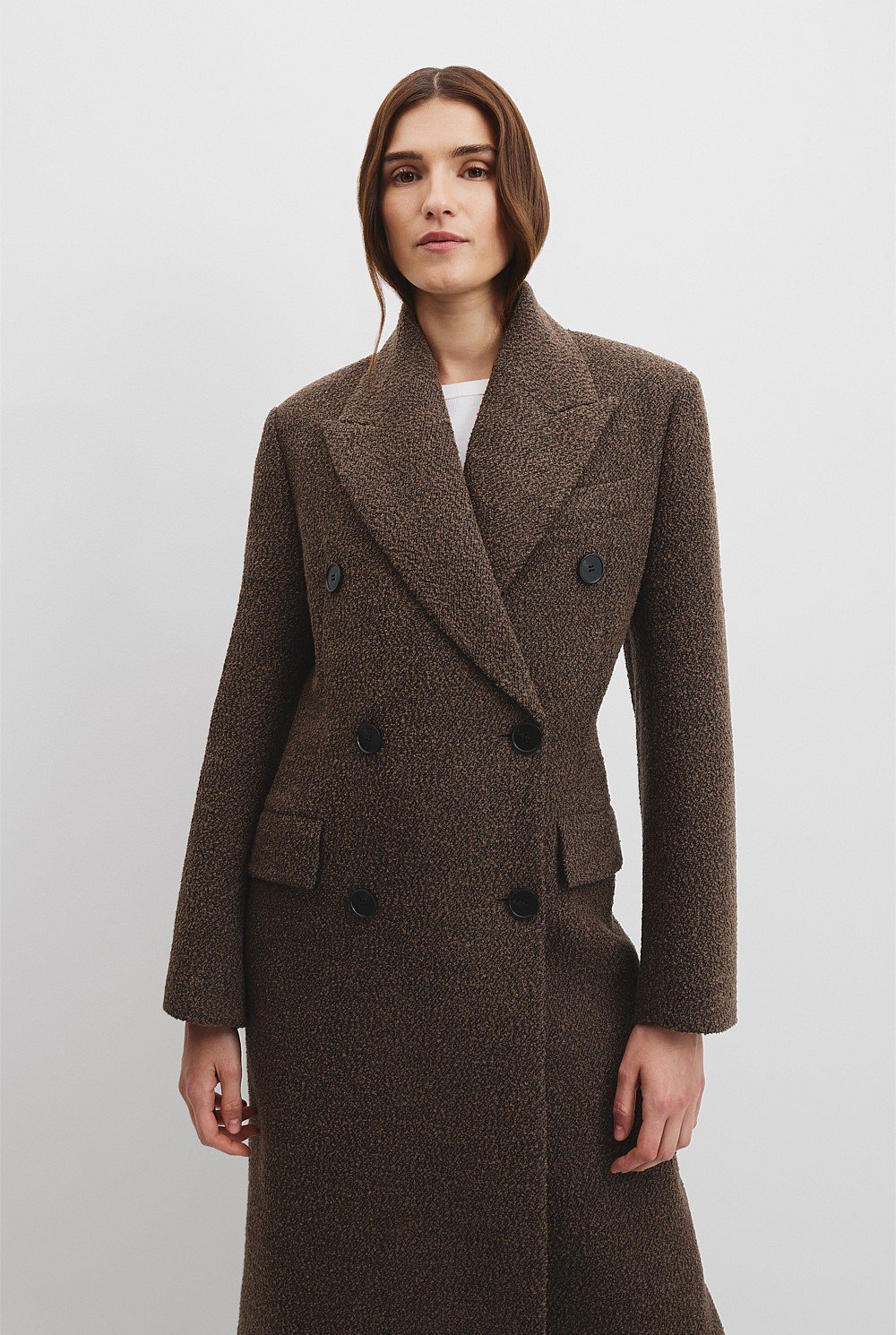 A white woman with brown hair wearing a brown boucle winter coat