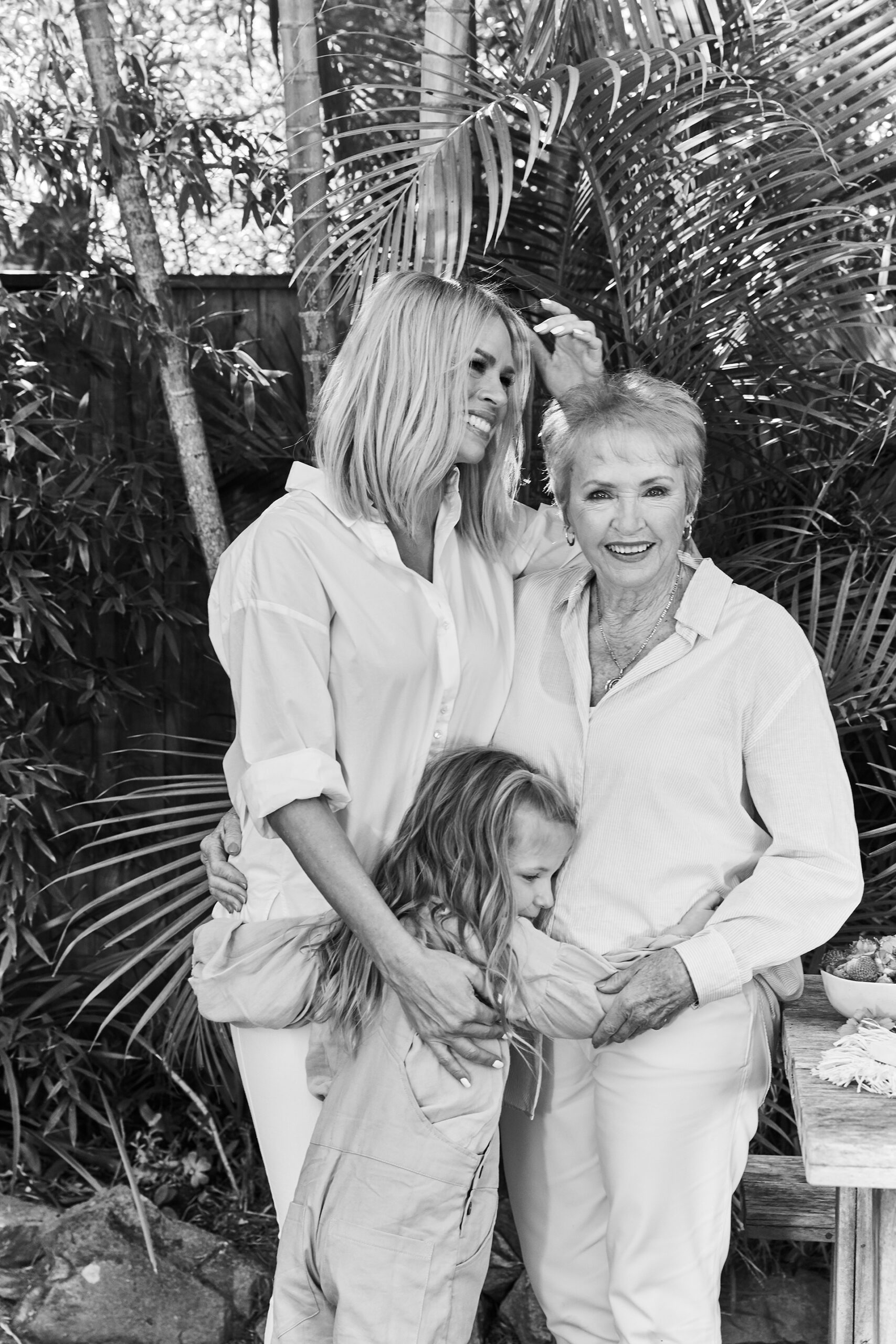 Margaret, Maggie and Sonia Kruger embrace in a black and white shot.