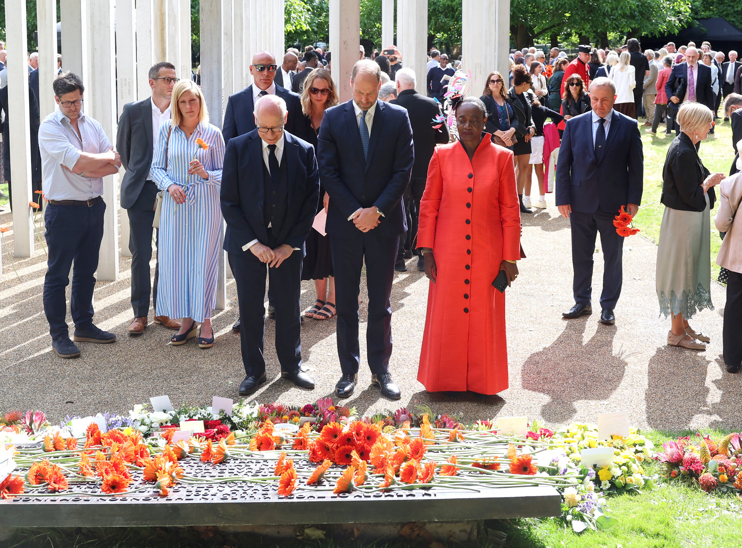 LONDON, ENGLAND - JULY 07: Prince William, Prince of Wales (C) stands with London bombings survivor Thelma Stober (R) during a memorial service for the 20th Anniversary of the 7th of July 2005 bombings at Memorial Gardens at Hyde Park on July 07, 2025 in London, England. Prince William, Prince of Wales joined survivors of attacks and family members of the victims for the service. (Photo by Chris Jackson/Getty Images)